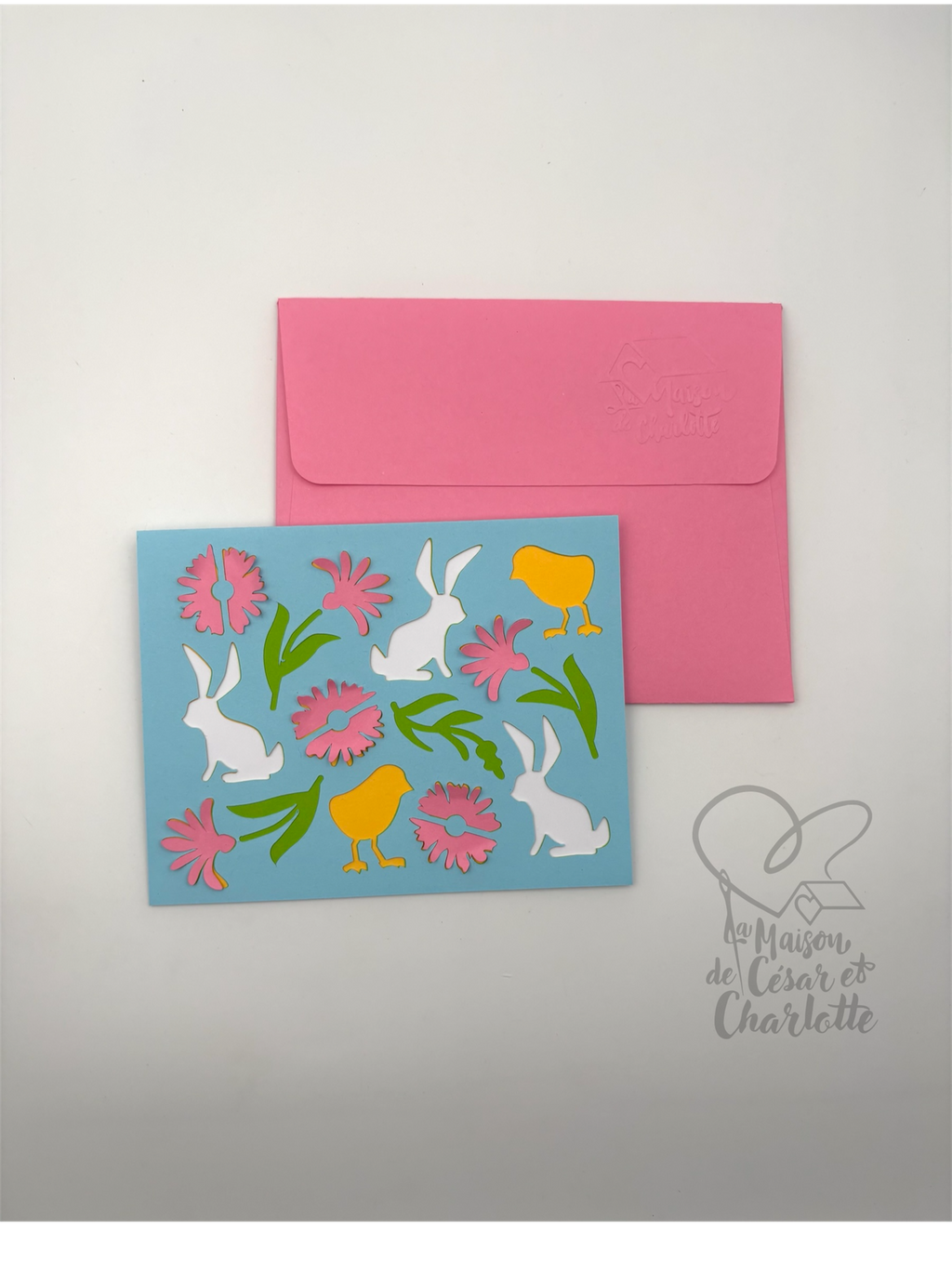 Carte de Pâques artisanale aux couleurs douces et printanières, décorée de petits lapins, poussins et fleurs